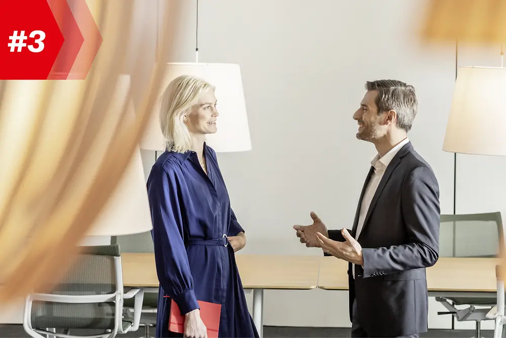 Uma mulher e um homem conversando em uma sala de conferências