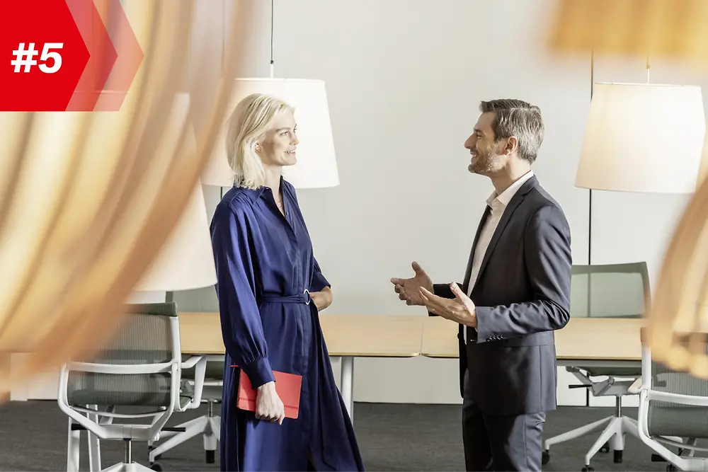 Uma mulher e um homem conversando em uma sala de conferências 